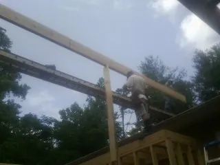 Carpenter setting a ridge beam over a new addition frame — Ice Dam Removal by Roofing Brothers in Newfields