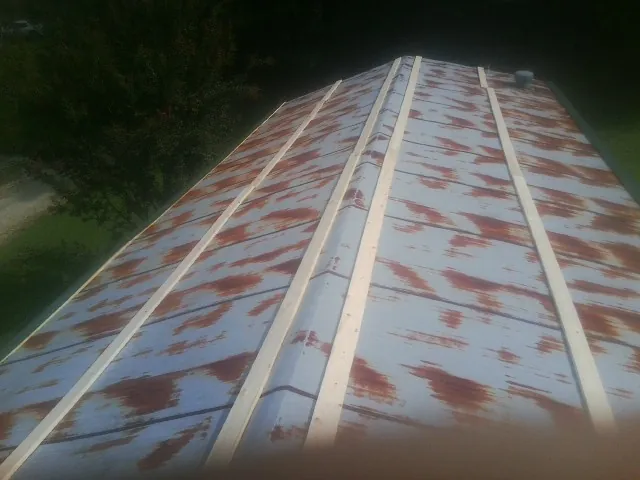 Rusted metal roof panels with new wood purlins before replacement — Storm Damage Roof Repair in Newfields by Roofing Brothers