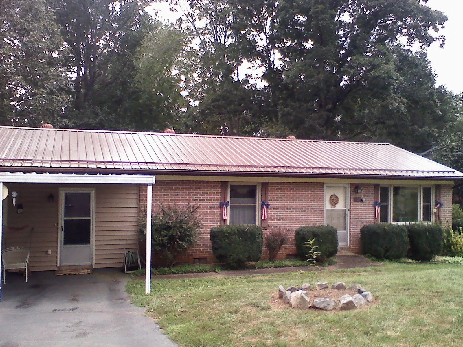 Bronze metal roof and carport on a brick ranch home — Roof Repair work by our crew in Newfields